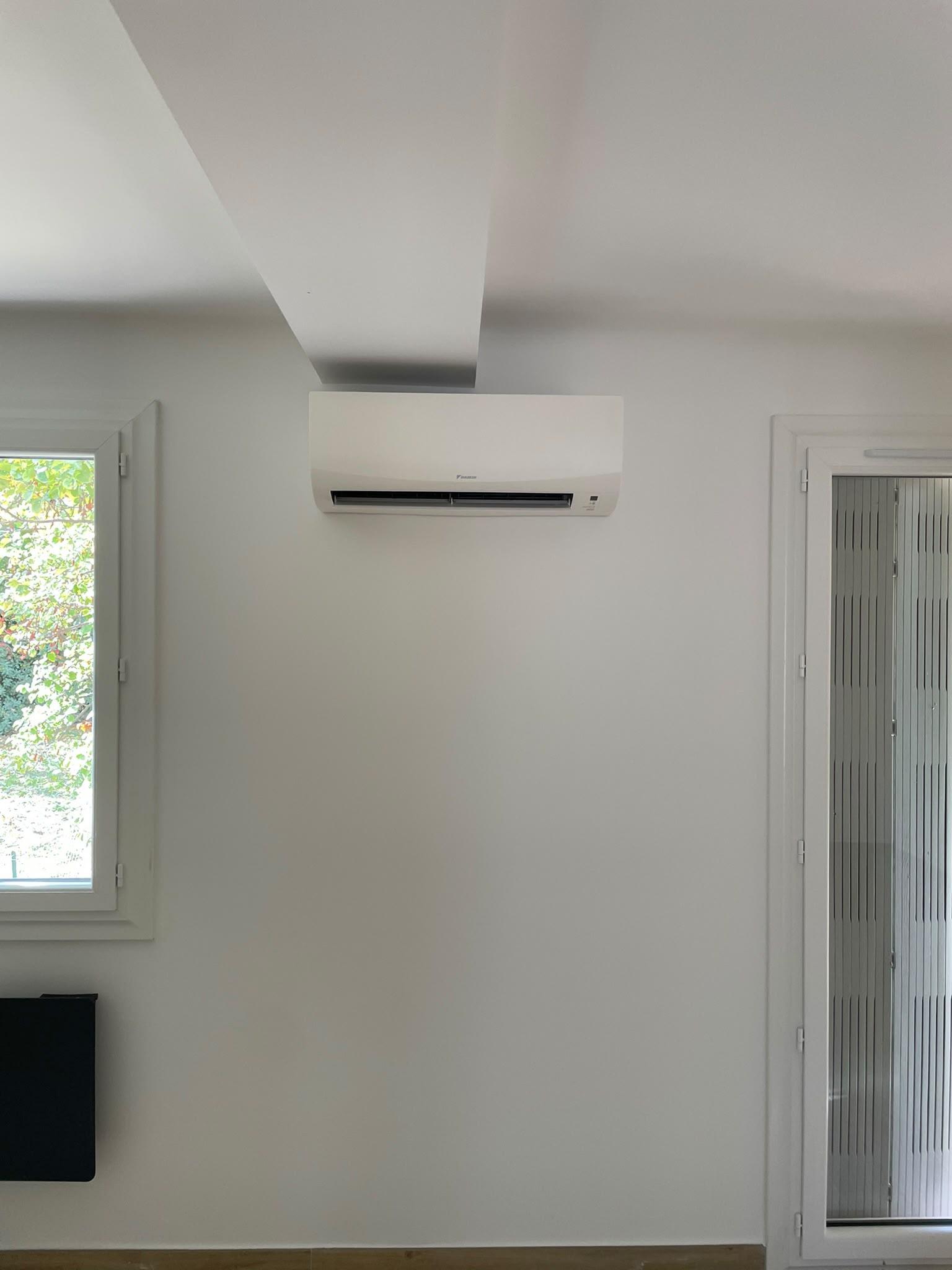 Split mural Daikin posé entre une fenêtre et un volet